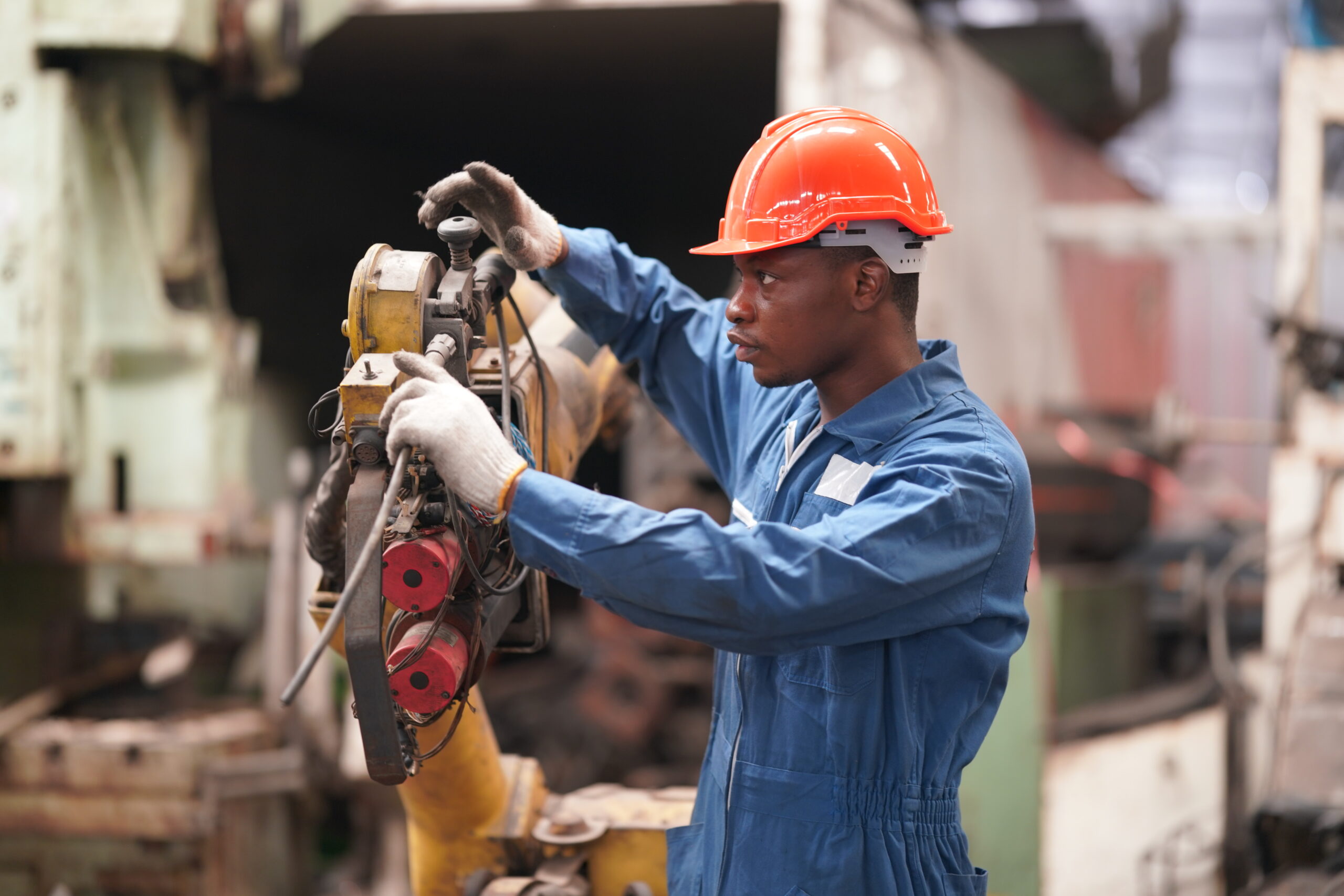 African American lathe worker working with milling machine in metal industry.